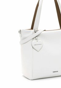 Bolso de piel blanca con un acabado texturizado, que presenta dos asas superiores y una correa de hombro desmontable. Etiqueta en forma de corazón adjunta que muestra el logotipo.