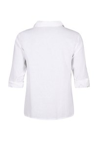 Camicia bianca in lino con colletto, maniche arrotolate e un design semplice e senza decorazioni. Texture morbida con un aspetto leggero.