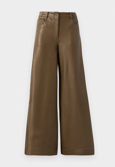 Laiad püksid, mis on valmistatud siledast pruunist kunstnahast. Omab kõrgendatud vööd, nelja taskut ja eesmist tõmblukk. Lame tekstuur ja minimalistlik disain.