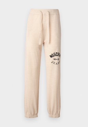 Calças de moletão bege com punhos e cintura elásticos. Apresenta um logótipo impresso a preto "MOSCHINO 86 ❤ 23 JEANS" na coxa esquerda. Textura suave.