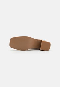 Helle Schuhsohle mit flachem Design. Texturiert für besseren Halt, mit einem glatten, abgerundeten Fersenbereich. Sauberer, minimalistischer Stil.