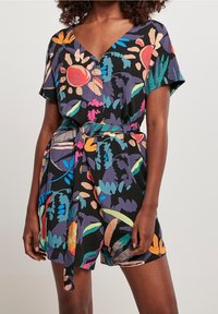 Blommönstrad romper i svart med livfulla flerfärgade mönster. Har korta ärmar, V-ringning och ett knytbart midjebälte.