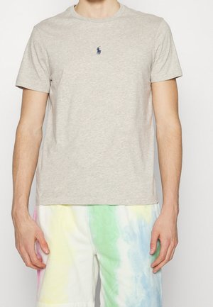 Graues Baumwoll-T-Shirt mit Rundhalsausschnitt und kurzen Ärmeln. Verfügt über ein kleines gesticktes Logo auf der Brust. Glatte Textur.