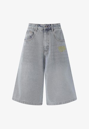 Light blue denim shorts with a loose fit, mid-rise waist, four pockets, and yellow embroidered logo on the front. Smooth texture, casual design.