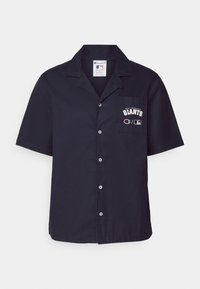 Marineblauwe korte mouwen overhemd met knopen in zachte stof, voorzien van een voorzak met het "San Francisco Giants" logo en het Champion merkembleem.