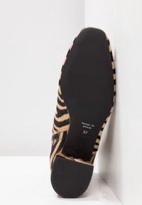 Chaussure à imprimé animalier avec un bout pointu, fabriquée en matériau à texture poilue à motifs beige et noir, dotée d'une semelle en caoutchouc noire, taille 37.