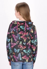 Jachetă cu model de fluturi multicolori, cu un fundal negru, glugă și manșete elastice. Textura moale a țesăturii și croiala lejeră.