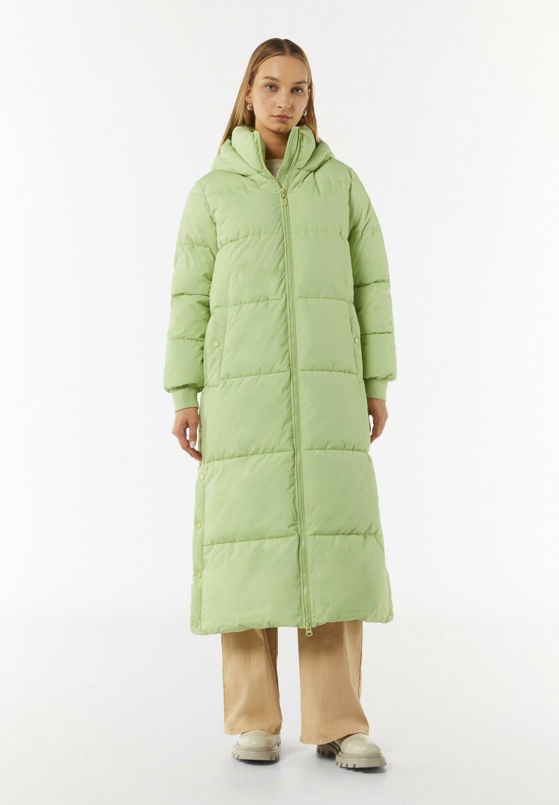 Padded long coat in light green, featuring a hood, front zipper, and snap buttons. Smooth texture with a straight cut and side pockets.