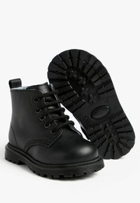 Schwarze Lederstiefel bis zum Knöchel mit runden Zehen, Schnürdesign und einer robusten Gummisohle mit einem gemusterten Profil für besseren Halt.