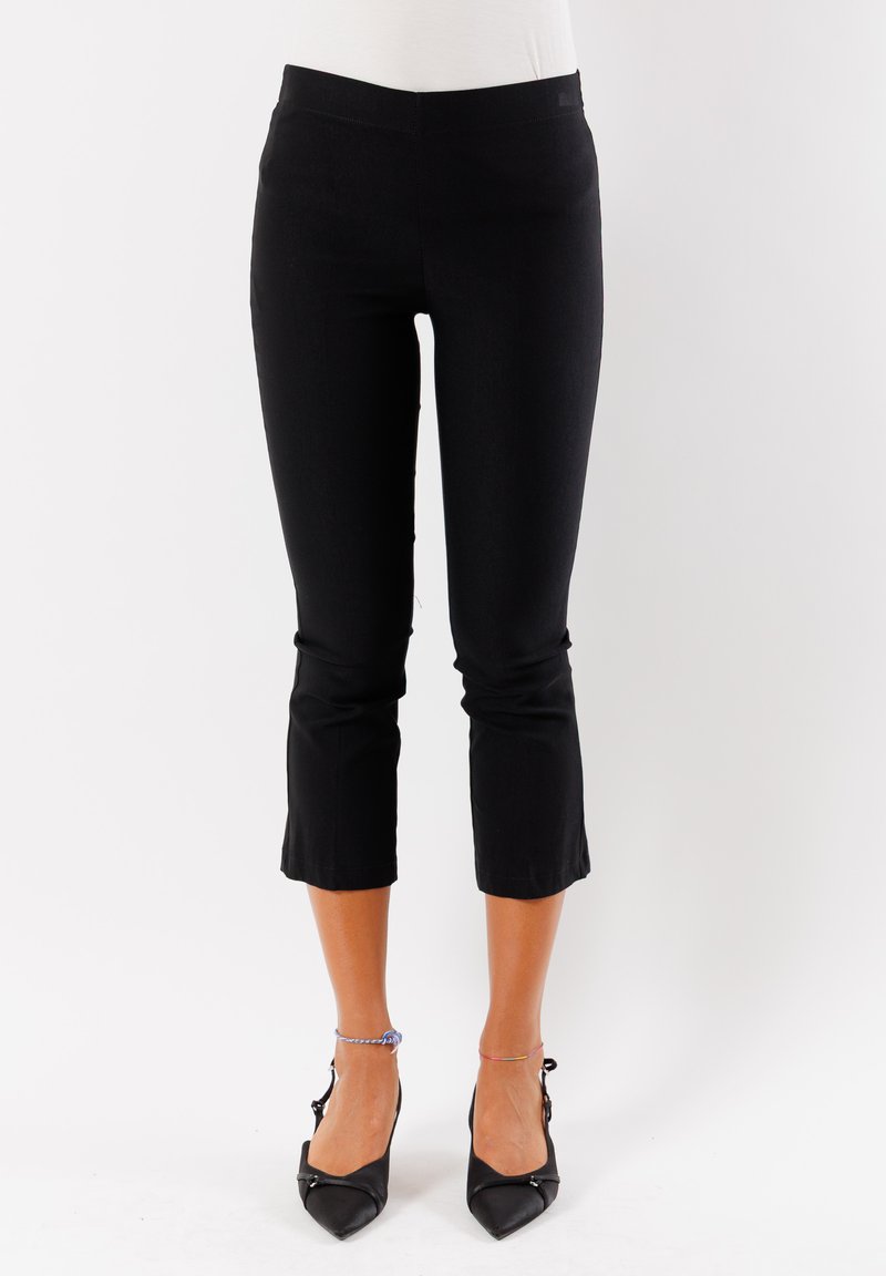 Pantaloni neri a 3/4 elasticizzati con una texture liscia e design aderente, caratterizzati da una vita media e un orlo appena sopra la caviglia.