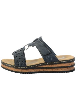 Dark blue sandal in leather with woven upper, featuring a metal ring accent. Cork midsole with black rubber outsole and beige footbed.