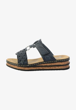 Sandale en cuir bleu foncé avec un dessus tressé, comprenant un accent en anneau métallique. Semelle intermédiaire en liège avec une semelle extérieure en caoutchouc noir et un plateau beige.