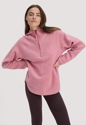 Hellrosa Fleece-Pullover mit einem halbseitigen Reißverschlusskragen, langen Ärmeln und einer entspannten Passform. Verfügt über eine dezente Textur und seitliche Schlitze am Saum.