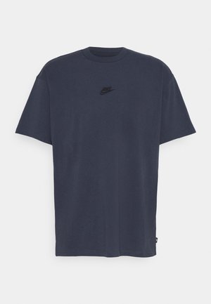 Ciemnoszary t-shirt z krótkim rękawem i okrągłym dekoltem, z małym czarnym logo Nike na środku klatki piersiowej.