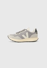 Grey mesh and suede sneaker with a cream-colored midsole, logo accent on the side, and black rubber outsole. Features flat laces and a textured finish.