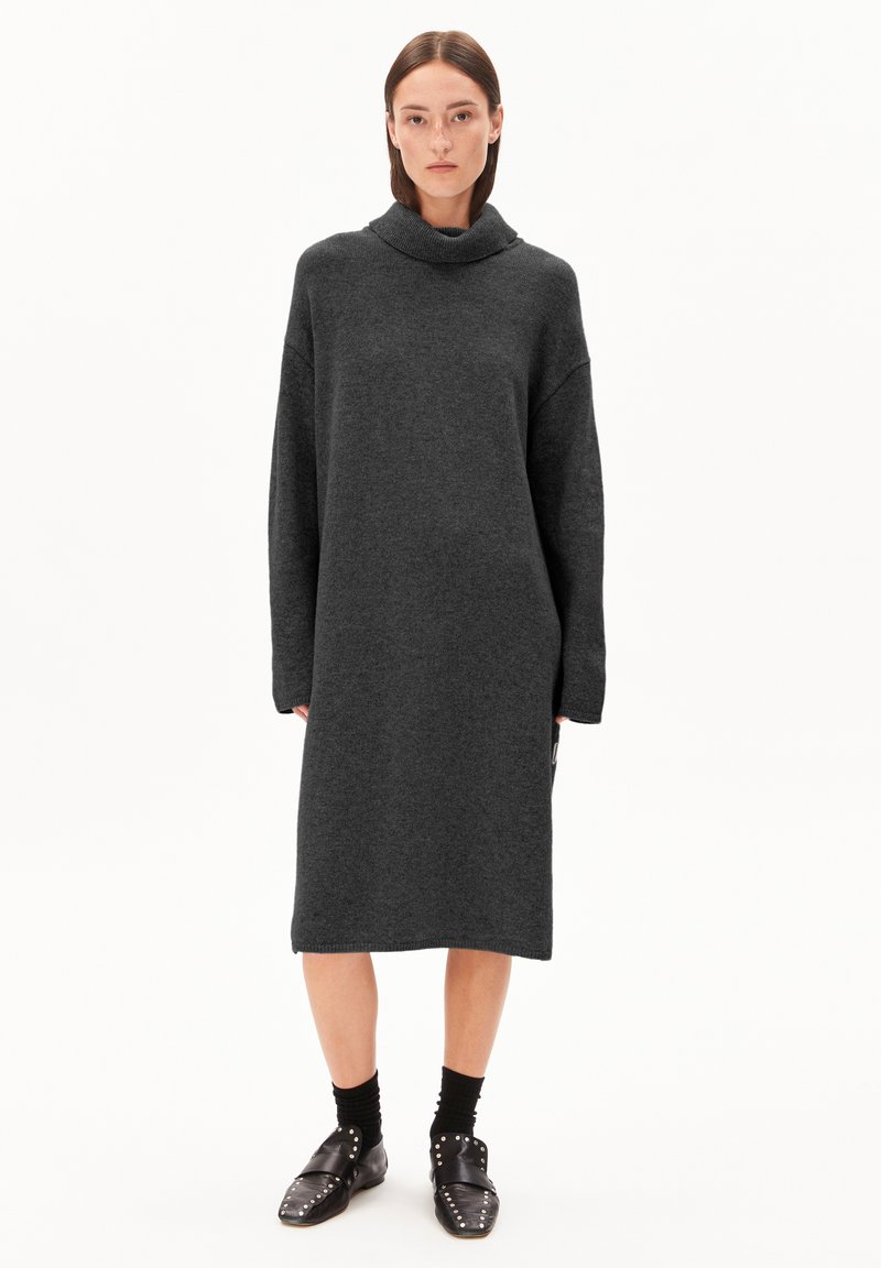 Robe oversized gris foncé avec un col haut et plié, des manches longues et une silhouette droite, fabriquée dans un tissu doux et texturé.