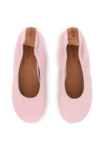 Ροζ δερμάτινες μπαλαρίνες με ελαστική επένδυση, λεία υφή και δερμάτινη λεπτομέρεια σε κανελί απόχρωση στη φτέρνα. Το εσωτερικό διαθέτει καφέ επένδυση.