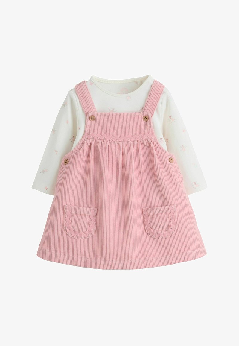 Pink corduroy pinafore dress with scalloped pockets layered over a white long-sleeve shirt with small pink floral prints for a baby.