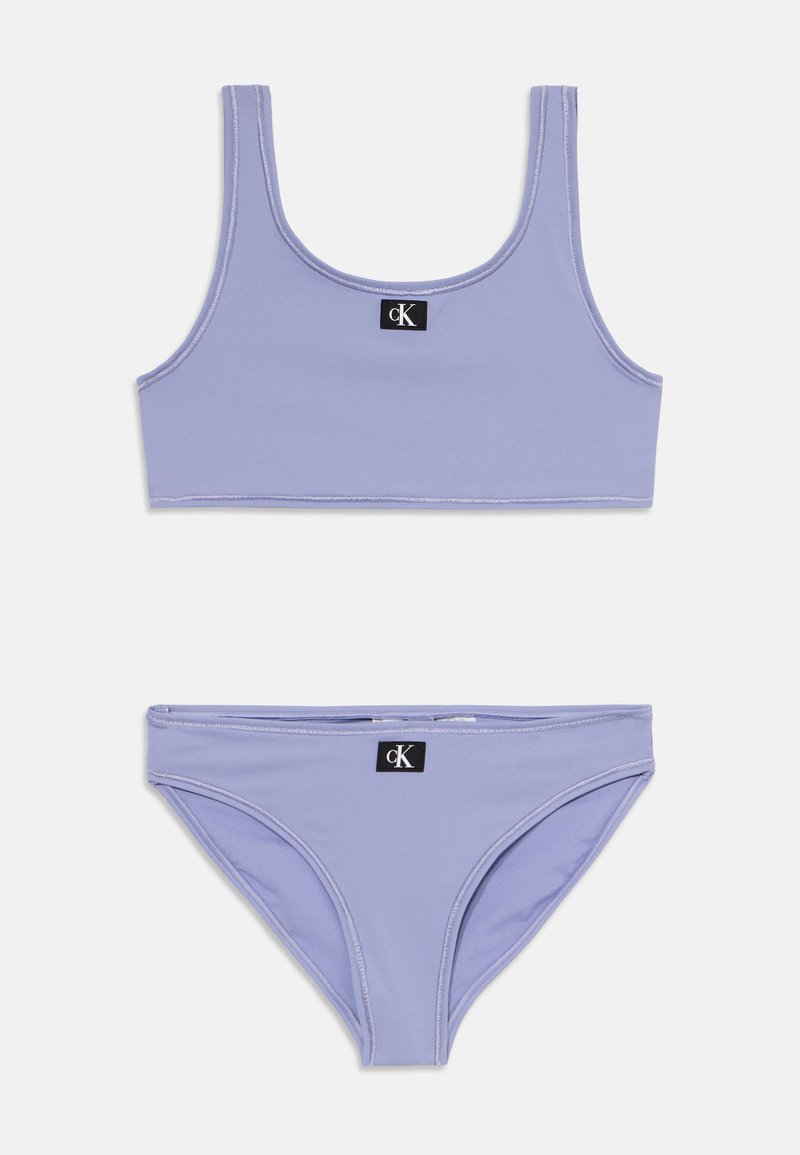 Lilla kaheosaline bikiinide komplekt, mis sisaldab lühikest tank topi ja bikiinipõhja, valmistatud siledast materjalist, millel on kontrastsed valged õmblused ja logo.