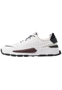 Scarpa da atletica bianca con design perforato, pannello laterale bordeaux a contrasto, suola in gomma testurizzata e dettagli neri sul tallone e sulla linguetta.