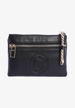 Funda de cuero negro con cremallera dorada, logotipo circular grabado y una correa con patrón. Textura suave y forma rectangular.