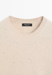 Beżowy sweter robiony na drutach z okrągłym dekoltem, teksturowana tkanina z wielokolorowymi wątkami i metką z napisem "Massimo Dutti" wewnątrz kołnierza.