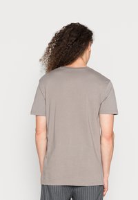 Grijze katoenen t-shirt met korte mouwen, ontspannen pasvorm, ronde halslijn, zachte textuur, zonder zichtbare graphics of patronen op de achterkant.