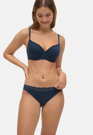 Sostén de color azul oscuro con tejido texturizado, aros y detalle de encaje. Braguita tipo bikini a juego con cinturilla de encaje. Ambos artículos tienen tirantes ajustables.