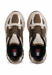 Para brązowych i beżowych mesh sneakersów z czarnymi akcentami, sznurowadłami oraz widocznym logo Tommy Jeans na języku i wkładce, widziane z góry.