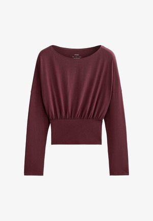 Bluză de culoare burgundy cu mâneci lungi, decolteu rotund, talie adunată și design scurtat. Confecționată dintr-un material moale, elastic, cu o textură fină.