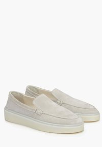 Světlé šedé semišové nazouvací boty s kulatou špičkou, polstrovanou stélkou a silnou bílou gumovou podrážkou. Minimalistický design bez viditelného kovového hardwaru.