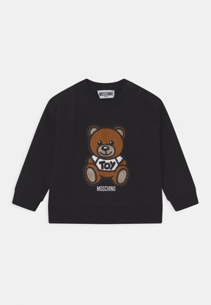 Schwarzer Baby-Pullover mit einem braunen Teddybär, der ein weißes Hemd trägt, auf dem "TOY" steht, und darunter der Schriftzug "MOSCHINO".