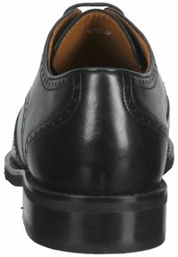 Scarpa da sera in pelle nera con texture liscia, punta tondeggiante e dettagli di cucitura sottili. Presenta una fodera interna color tan e un tacco robusto.