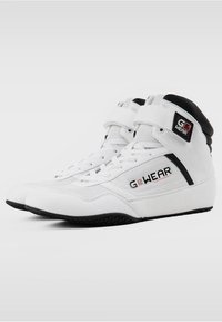 Witte hoge sneakers met een zwarte accent bij de hiel, voorzien van een gestructureerde suède afwerking, veters en een logo-patch aan de zijkant.