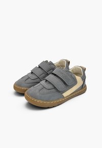 Paire de baskets pour enfants gris et beige avec double fermeture velcro et semelles en caoutchouc marron sur fond blanc.