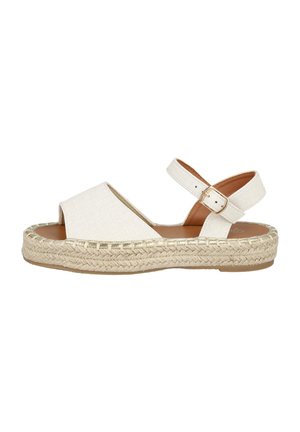 Sandalia de esparto beige con punta abierta, correa de tobillo ajustable, mediopié de cuerda de yute y suela de goma plana. Parte superior de tejido texturizado con acentos metálicos.