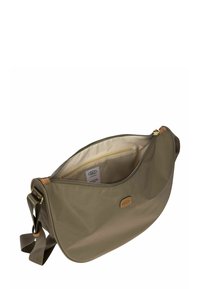 Sac bandoulière vert olive avec bandoulière réglable, partiellement ouvert montrant l'intérieur beige et une poche zippée à l'intérieur.