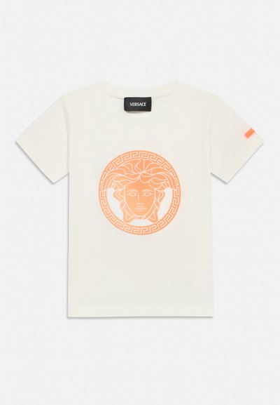 Λευκό T-shirt με κοντά μανίκια και πορτοκαλί λογότυπο με κεφάλι Μέδουσας στο κέντρο μπροστά, με μαύρη ετικέτα Versace στον λαιμό.