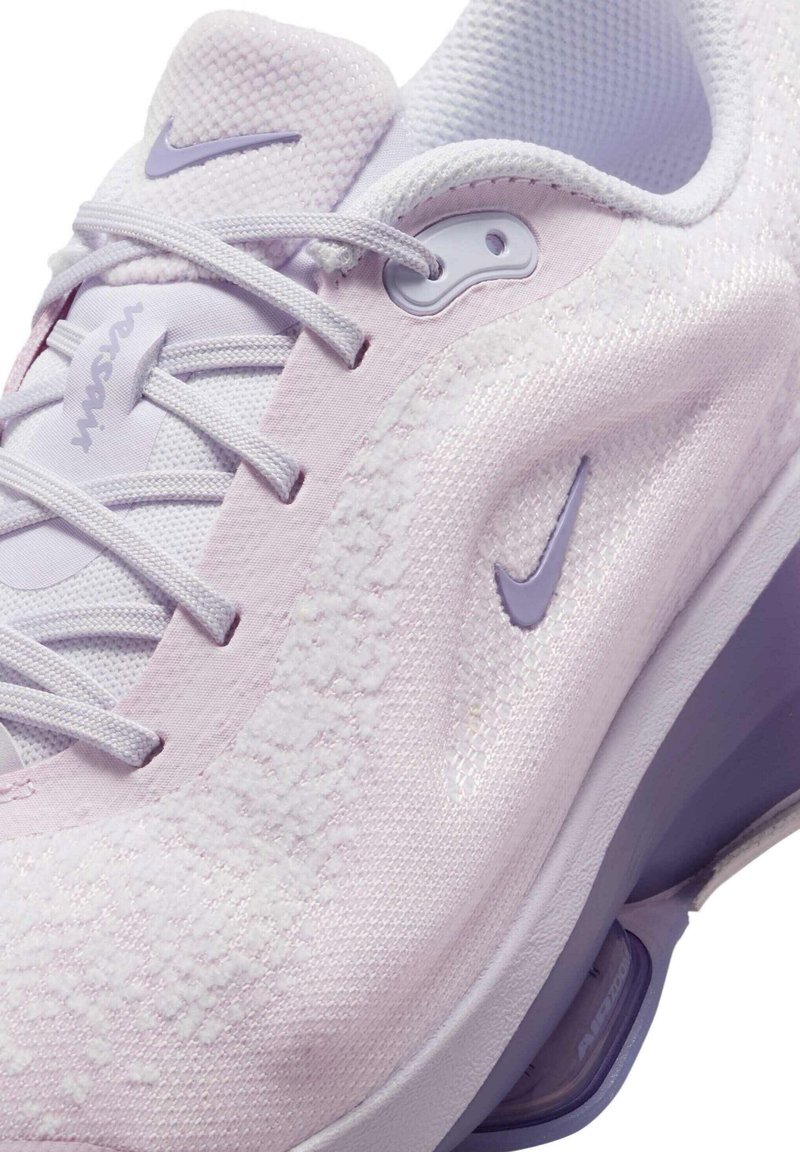 Scarpa da ginnastica viola chiaro con tomaia in tessuto testurizzato, dettagli bianchi e un piccolo logo Nike viola sul lato. Presenta lacci e una linguetta imbottita.