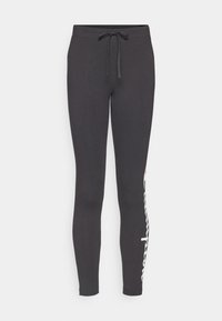 Svarta sweatpants med en figursydd design, elastisk midja och justerbar dragsko. Har vit logotryck längs vänster ben.