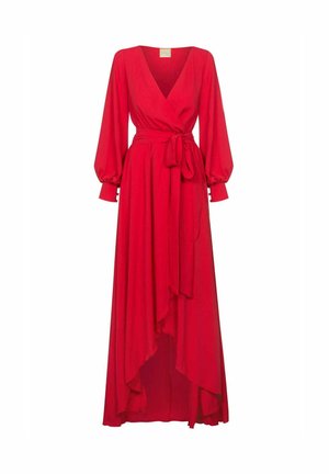 Czerwona sukienka o kroju kopertowym uszyta z lekkiego materiału, z dekoltem w serek, długimi bufkami i paskiem do wiązania. Doły sukienki są nierówne, co tworzy zwiewny kształt.