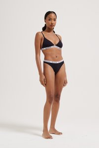 Ensemble de bikini noir comprenant un soutien-gorge triangulaire avec une bande élastique à logo et un bas de bikini assorti, le tout en tissu doux.