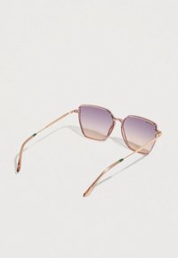 Šešiakampiai akiniai nuo saulės su šviesiai rožiniais rėmeliais ir gradientinėmis lęšiais. Metalinės aukso spalvos kojelės ir žalios detalės ant ausų galiukų.