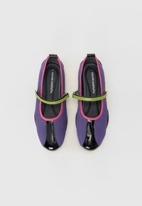 Sapatilhas de balé em rede roxa com pontas em verniz preto, detalhes em rosa e uma alça verde. Design elegante com textura suave e cores contrastantes.