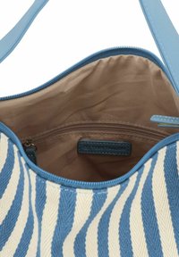 Sac en tissu rayé bleu et blanc avec un intérieur lisse, doté d'une poche zippée et d'une étiquette de marque à l'intérieur.