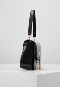 Borsa nera e grigia con un design testurizzato e plissettato. Presenta una finitura lucida in vernice, dettagli in oro e una catena sul fermaglio.