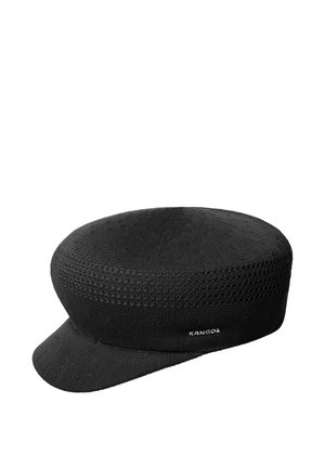 Gorra negra de punto con parte superior plana, visera corta y curva y pequeño logo de Kangol en el lateral, aislada sobre fondo blanco.