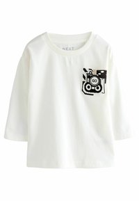 T-shirt bianca a maniche corte con scollatura rotonda e un design della tasca grafico in bianco e nero che presenta un treno e la parola "GO".