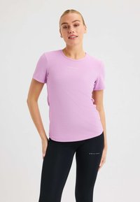 Ljuslila kortärmad träningsskjorta med rund halsringning och textilstruktur, som matchas med svarta tights med logodetalj.