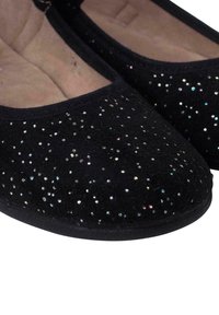 Zapatos planos negros de tela suave con un diseño de lentejuelas brillantes en la parte superior. Punta redondeada con una plantilla acolchada para mayor comodidad.